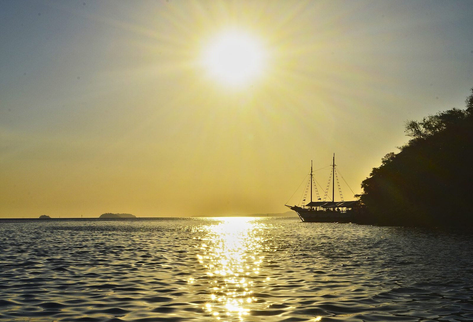 A schooner heads out across calm water in the golden early light, bound for the day's snorkeling coves.