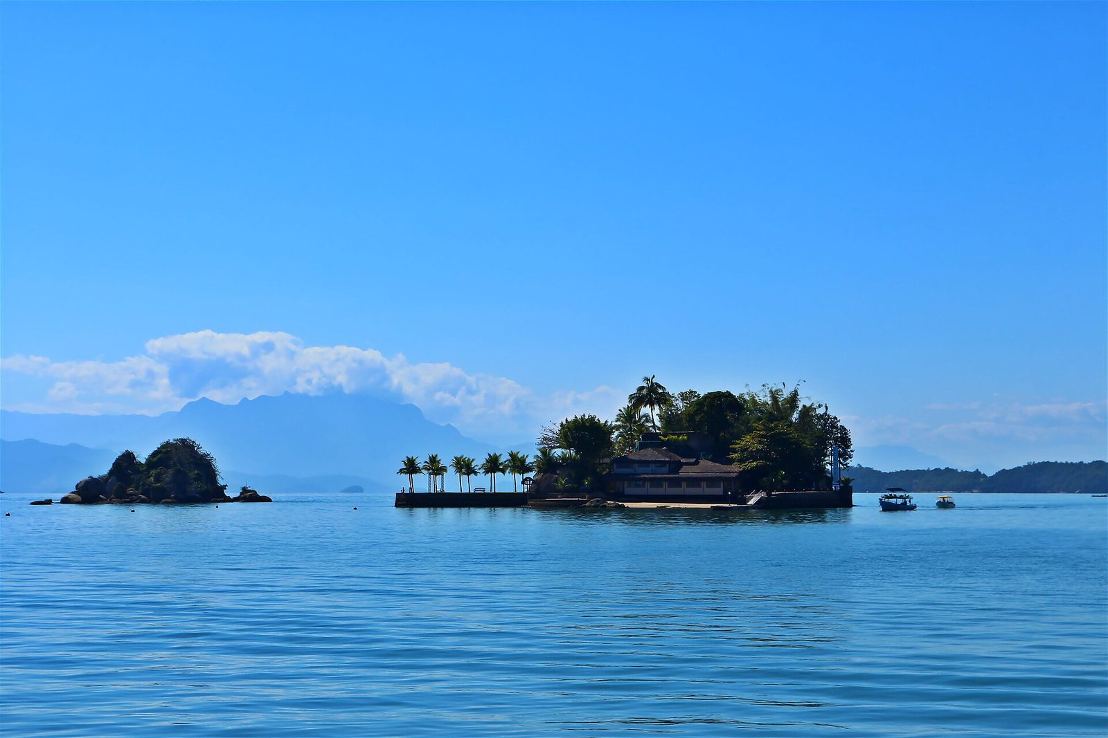 Small forested islands scattered across the calm water of the bay, the kind of scenery a schooner threads between all day.