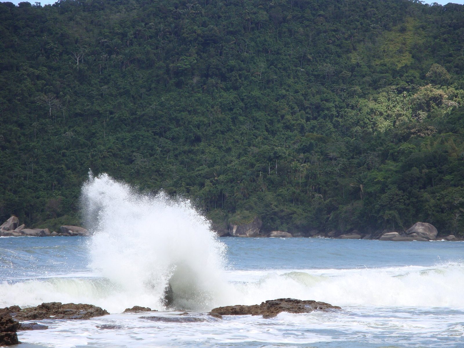 Waves rolling into an open, ocean-facing beach at Trindade — the surf that first drew visitors here, and a reminder to respect the water.